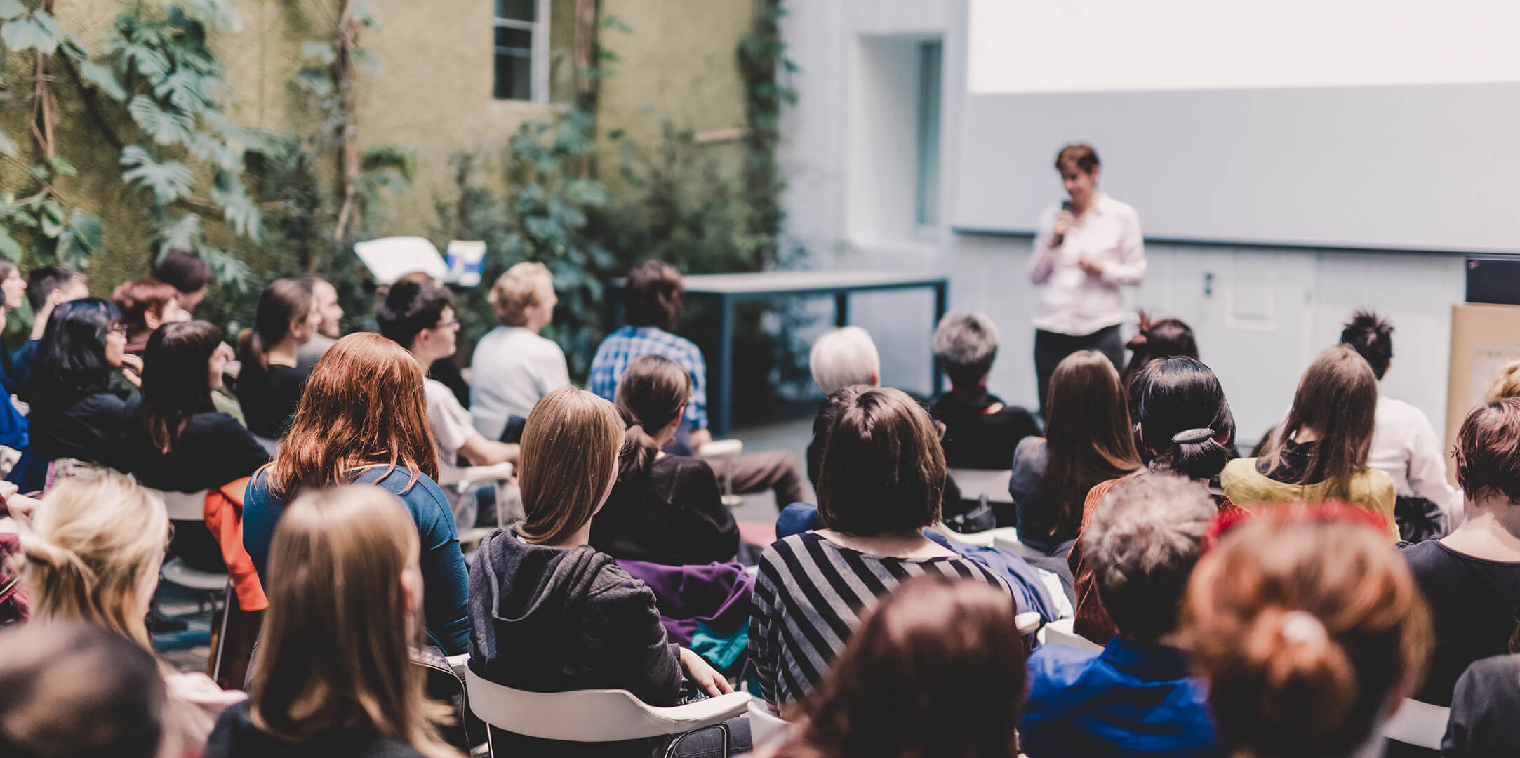 Woman giving presentation in lecture hall at university.